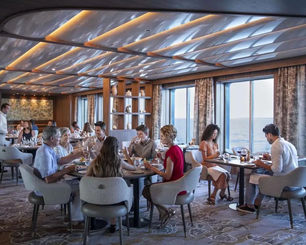 People sitting around dinner tables Celebrity Cruises' Flora cruise ship - Viking Travel