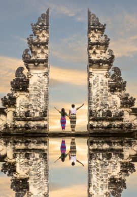 Happy couple standing in the gates of the temple of heaven, holding each other's hand. - Viking Travel