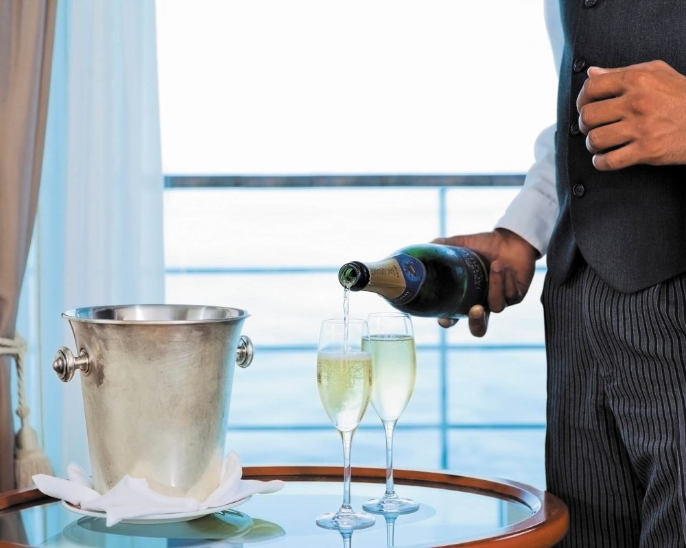 Butler pouring wine on a Regent Seven Seas cruise - Viking Travel