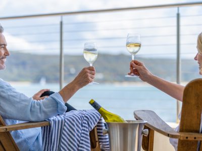 Couple drinking wine out on the deck of cruise ship - Viking Travel