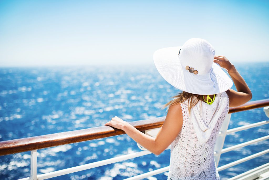 Woman with hat on a cruise ship looking at the view - Viking Travel