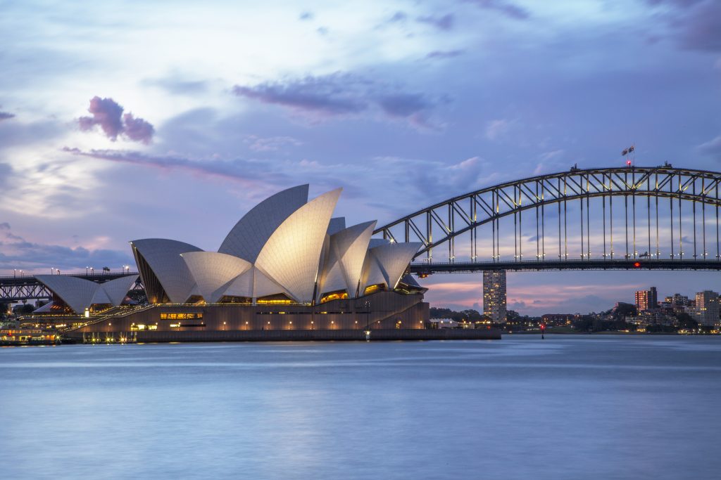 Sydney Opera House and Sydney Harbour Bridge illuminated at dusk - Viking Travel