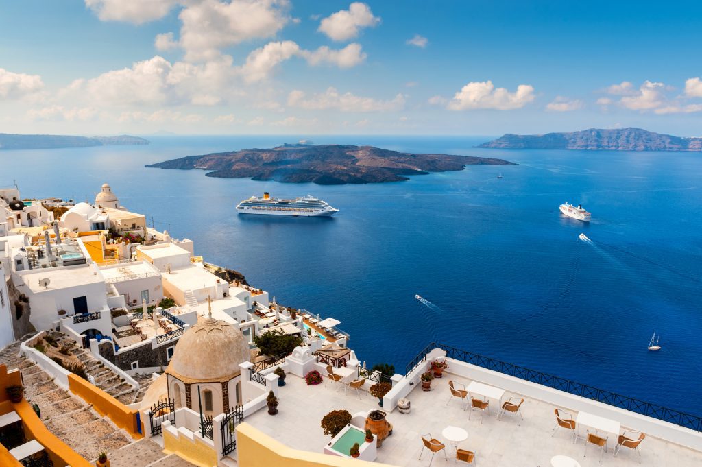 Santorini, Greece, Wide angle view of the cliff side buildings and large cruise ship - Viking Travel