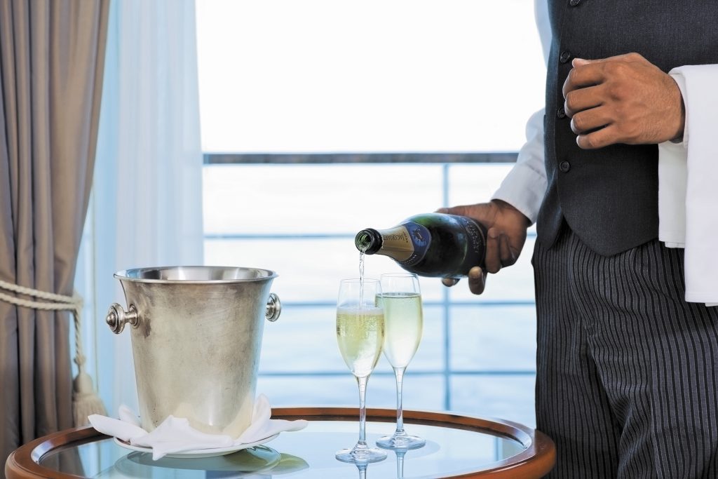 Regent Seven Seas butler pouring champagne - Viking Travel