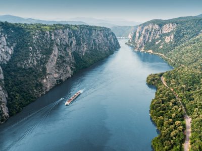 Aerial view of a cruise ship traveling through the Danube River's Iron Gate between Serbia and Romania - Viking Travel