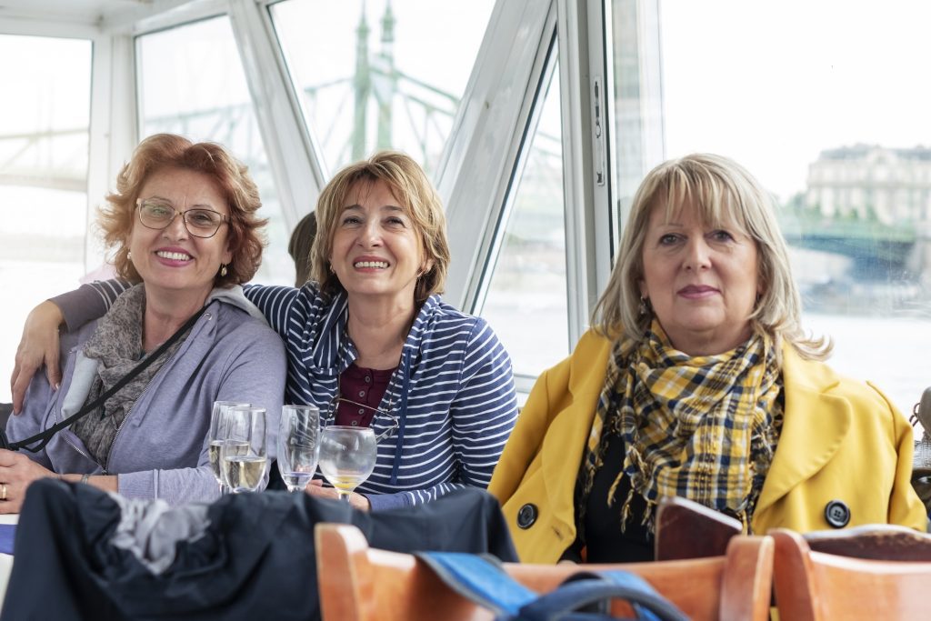Senior women sitting in a deck cabin of a cruise ship and exploring the city.